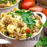 Hearty orecchiette pasta mixed with tomatoes, herbs, sausage and broccoli rabe (rapini) is a rustic and flavorful meal that's easy to prepare!