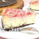 Cheesecake topped with a tart raspberry swirl on top of a decadent chocolate crust.